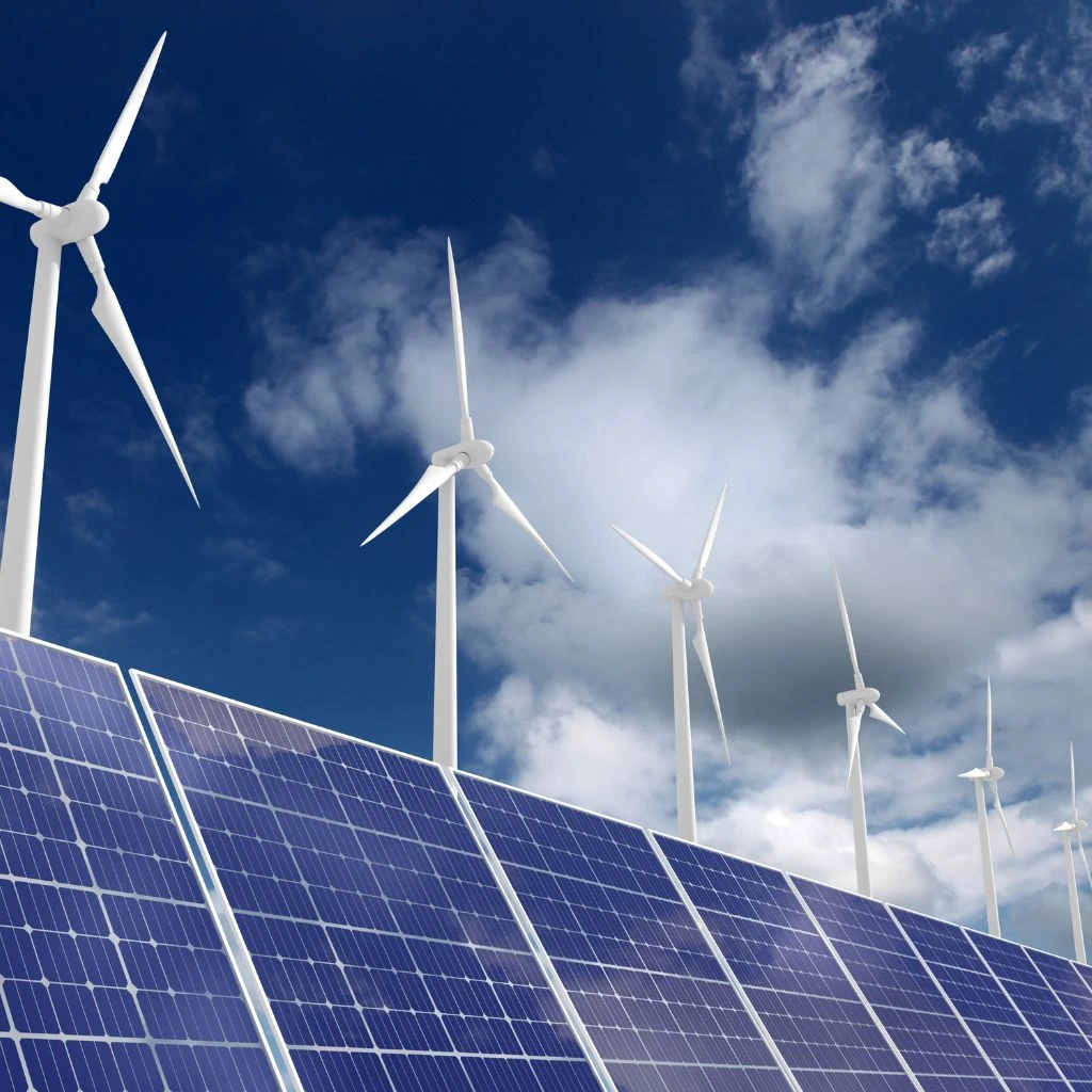 Molinos de viento con placas solares en un día soleado. Hace referencia a que abogado para energías renovables